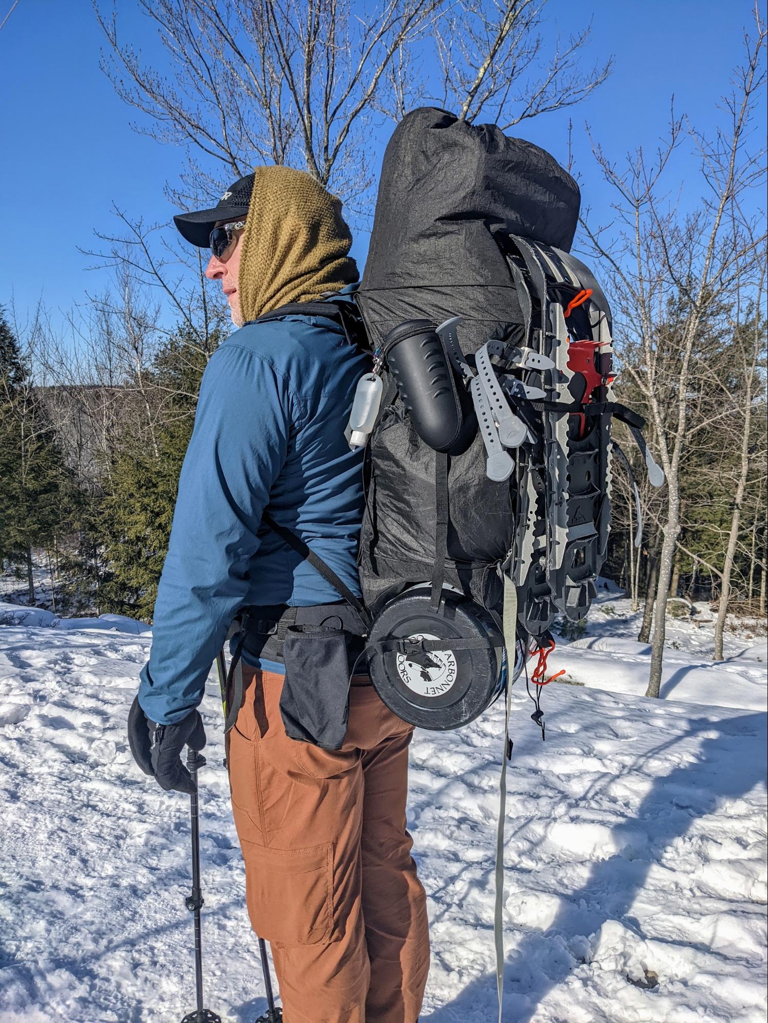 a man with a backpack and skis in the snow