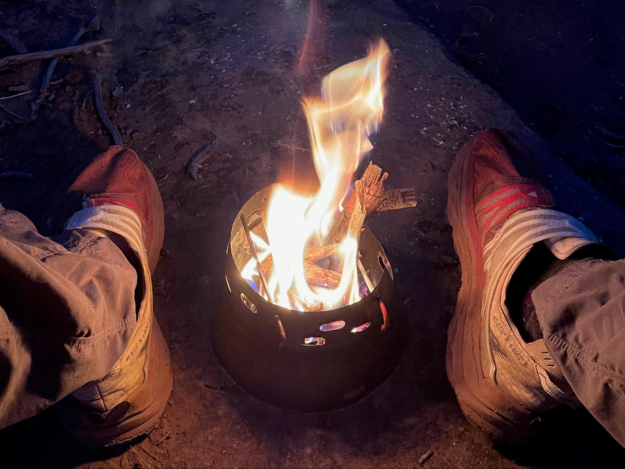 a person standing next to a fire in a pot