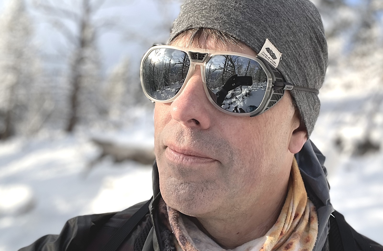a man wearing sunglasses and a hat in the snow